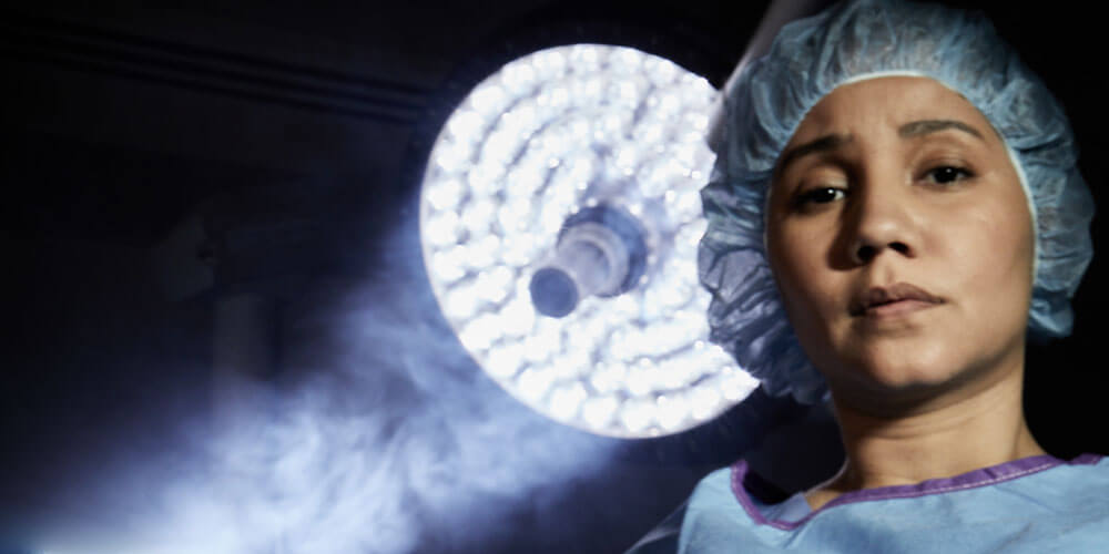 medical professional in front of smokey OR light